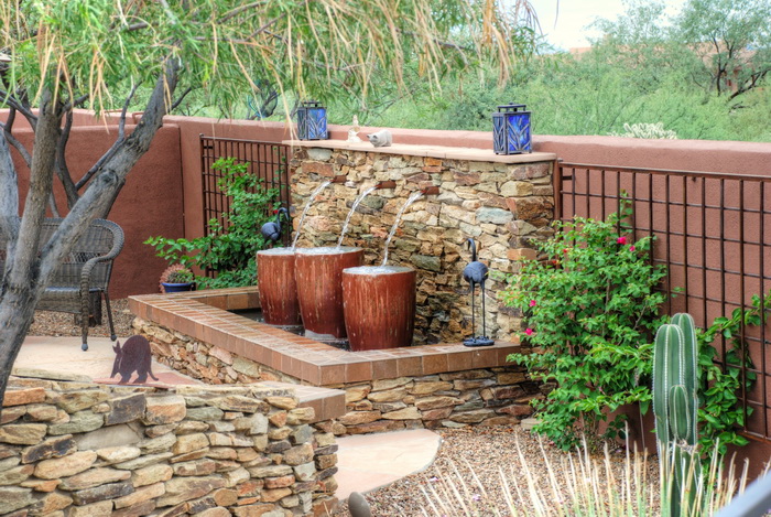Custom stacked-stone wall water feature with desert plantings